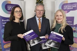 Dr Corr, Minister Nesbitt and Commissioner Designate for Victims of Crime Hanna holding copies of executive summaries of the report.